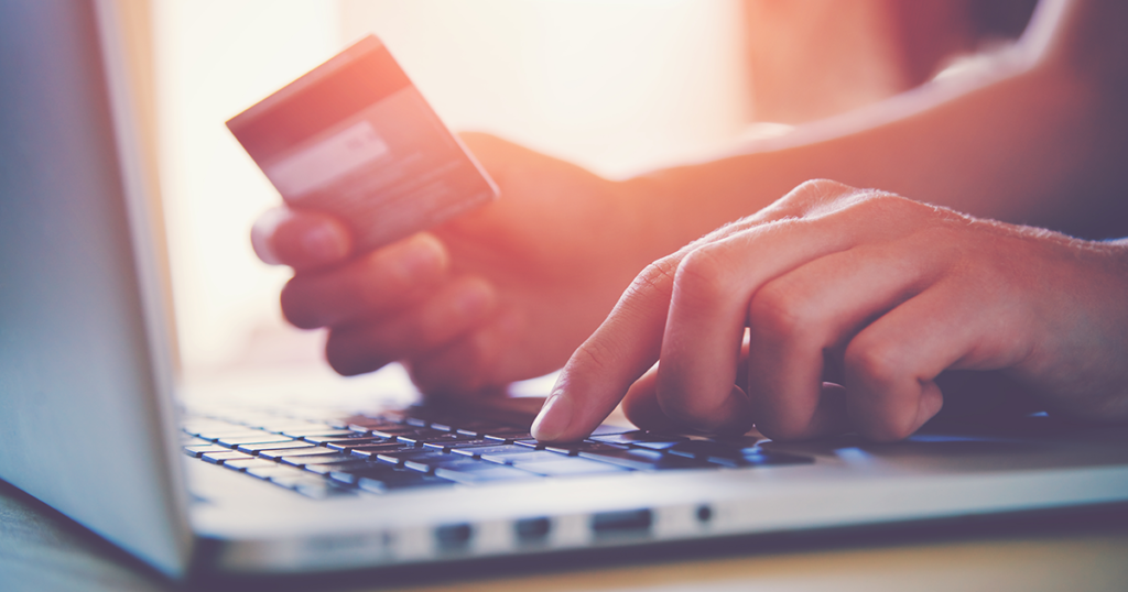אישה מחזיקה אשראי ועושה קניות באינטרנט
